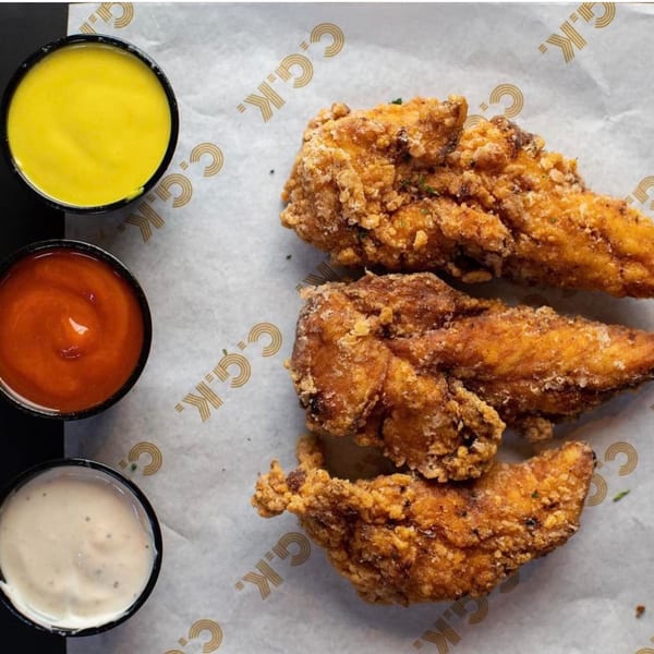 Crispy fried chicken tenders with three dipping sauces: honey mustard, ketchup, and ranch.